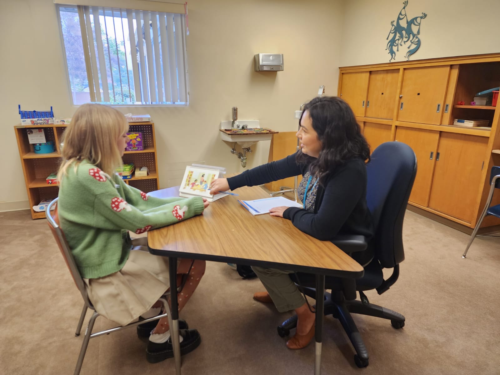 a speech-language pathologist assessing a student at a table