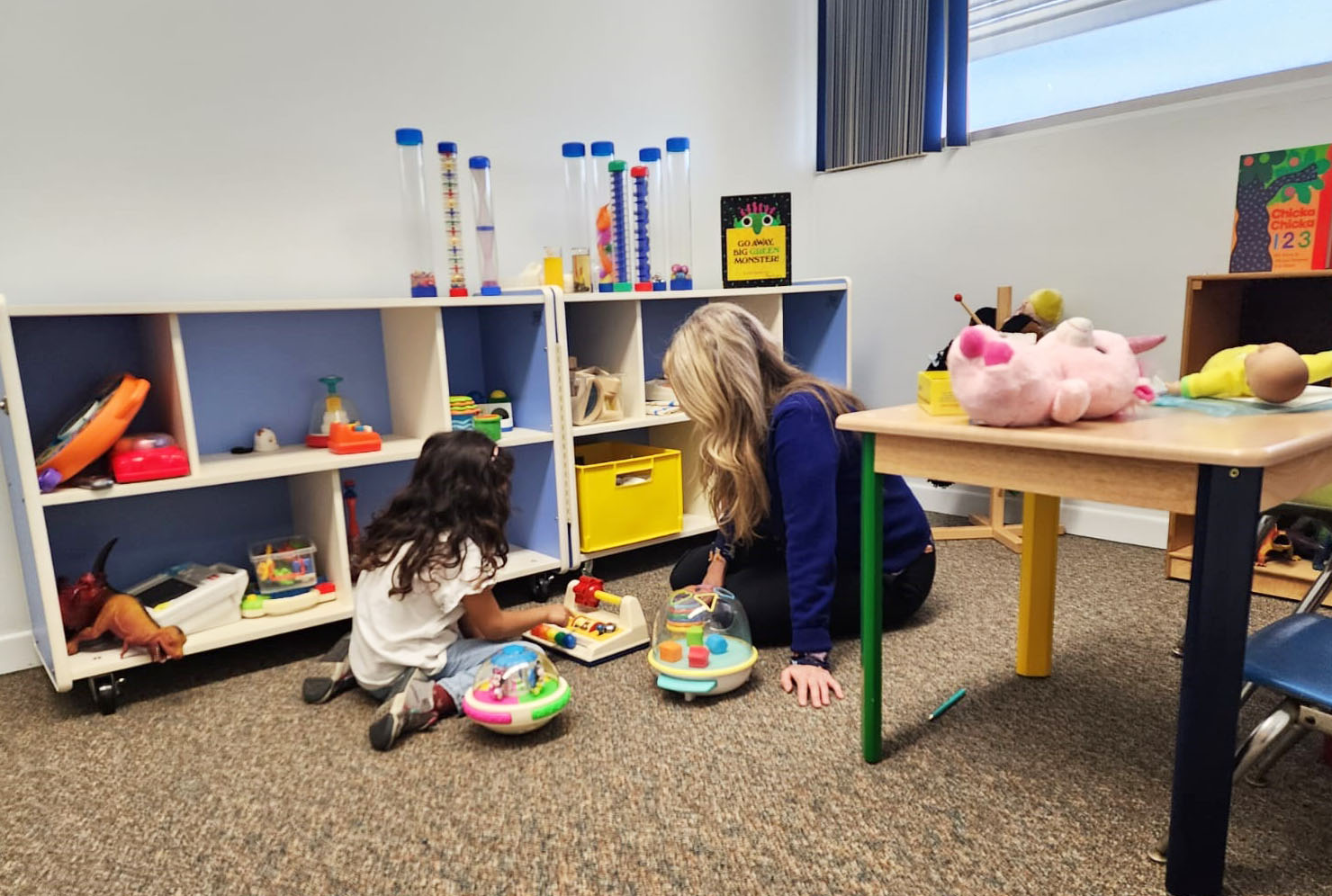 Amy plaing on the floor with a student