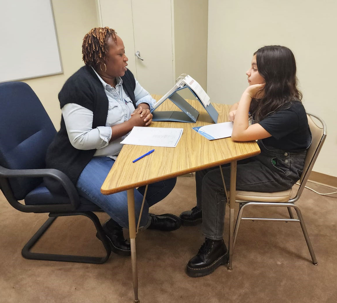 a person working with a student at a table