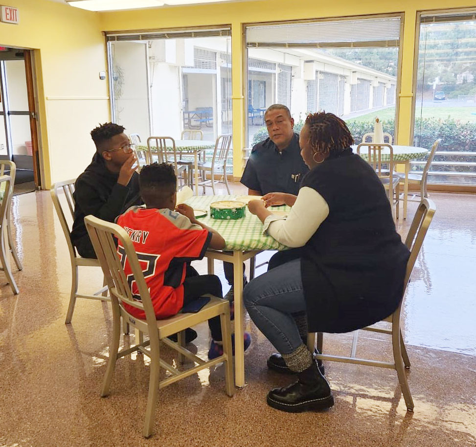 a child and three of his family members sitting around a table