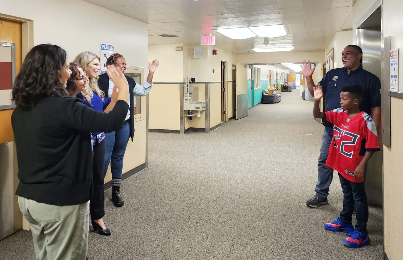 the assessment team waves to a student and his family